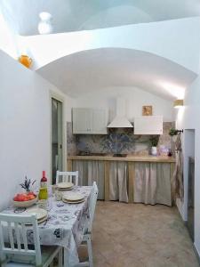 une salle à manger avec une table et une cuisine dans l'établissement Kamares, à Nardò