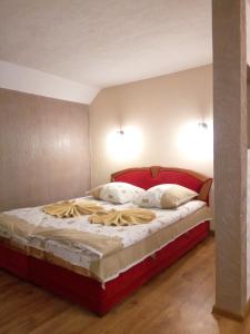 1 cama con cabecero rojo en una habitación en Sadyba Lesivykh, en Slavske