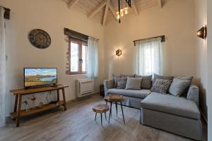 a living room with a couch and a tv at Patriko House in Plakias