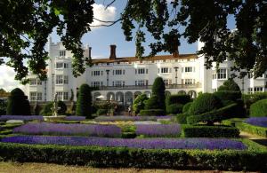 a garden with purple flowers in front of a white building at Danesfield House Hotel And Spa in Marlow