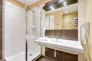La salle de bains est pourvue d'un lavabo et d'une douche. dans l'établissement Relais Akena La Brède, à La Brède