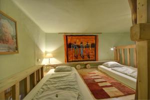 2 camas en una habitación con un cuadro en la pared en ARTHARMONY Pension & Hostel, en Praga