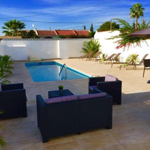 プレヤス・デ・オリフエラにあるCampoamor Villa & Private Pool, Garden & Roof Terraces Distant Sea Viewsのパティオ(プール、テーブル、椅子付)