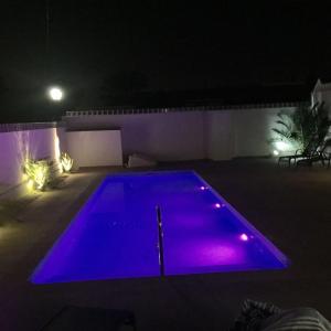 プレヤス・デ・オリフエラにあるCampoamor Villa & Private Pool, Garden & Roof Terraces Distant Sea Viewsの紫色の夜間照らされたスイミングプール