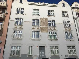 a white building with windows and a painting on it at Apartsee Hálkova in Pilsen