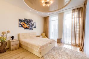 a bedroom with a bed and a large window at Panorama Apartment in Dnipro