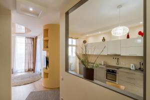a kitchen with white cabinets and a large window at Panorama Apartment in Dnipro