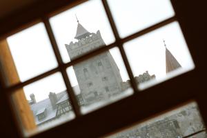 a view of a castle seen through a window at Conacul Törzburg in Bran