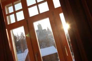 an open window with a view of a church at Conacul Törzburg in Bran