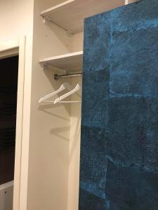 a closet with hangers and a blue stone wall at Bright apartment near Akropolis in Vilnius