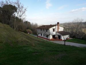 a white house sitting on top of a green hill at Camere Montalbano in San Miniato