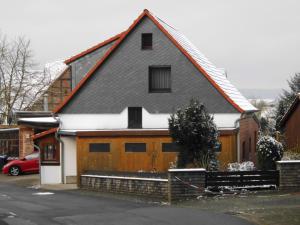 a wooden house with snow on the roof at Ferienwohnung Papsdorf in Bad Münder am Deister