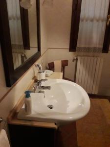łazienka z białą umywalką i lustrem w obiekcie Camere Montalbano w mieście San Miniato