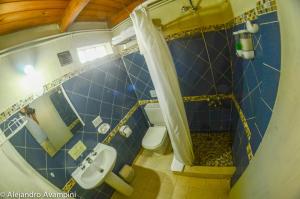 een kleine badkamer met een toilet en een wastafel bij De Luna in Puerto Pirámides