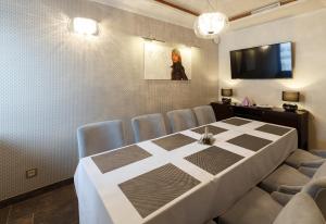 una sala da pranzo con tavolo, sedie e TV di Hotel Bystrá a Snina