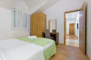 a bedroom with a bed and a desk and a mirror at APARTMANI SKELIN***/**** in Kaštela