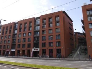 een groot gebouw van rode baksteen in een stadsstraat bij Modern Apartment in City Center in Krakau