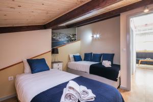 two beds in a room with blue and white at Camarinha Oporto Apartments in Porto