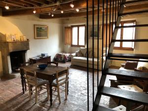 a living room with a wooden table and a staircase at Il Nido sulla Ruga in Anghiari
