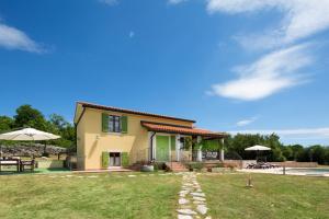 a house with a grass yard with a patio at Villa Valmont in Labin
