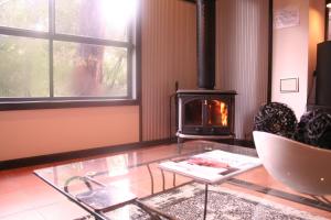 a living room with a glass table with a fireplace at Heavenly Retreat in Halls Gap