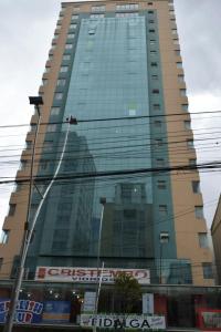 wysoki budynek z mnóstwem okien w obiekcie Miraflores Apart w mieście La Paz