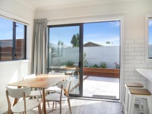 uma sala de jantar com mesa e cadeiras e uma grande janela em Twizel Cottages em Twizel