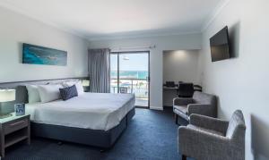 a hotel room with a bed and a balcony at Ocean Centre Hotel in Geraldton