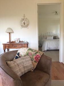 a living room with a couch and a bed at Little Lake Cottage in Nyora