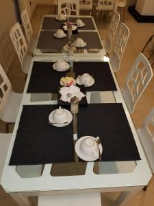 a long table with plates and napkins on it at Vamos Guest House in Addis Ababa