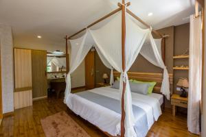 1 dormitorio con 1 cama con dosel en West Sands en Ukulhas