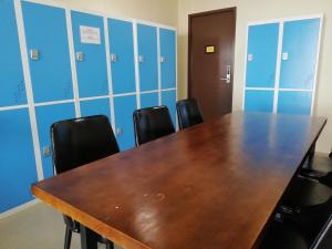 a conference room with a wooden table and black chairs at Spacepod@com in Singapore