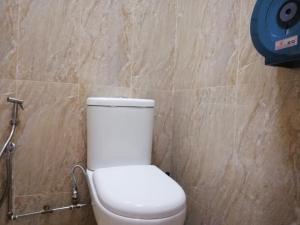 ein weißes WC im Bad mit einer Steinmauer in der Unterkunft Spacepod@com in Singapur