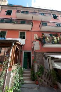 un edificio rosa con escaleras y plantas delante en Affittacamere Dune Blu, en Riomaggiore