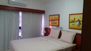 a bedroom with a white bed and a window at Ondina Apart Hotel Residence in Salvador