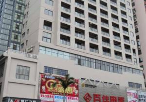 a tall white building with a billboard in front of it at Jinjiang Inn Sanya International Shopping Center Seaview in Sanya