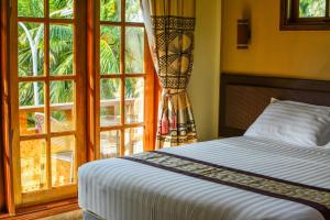 a bedroom with a bed and a large window at Remora Inn in Faafu