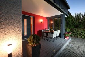 einen Balkon mit einem Tisch und Stühlen auf einem Haus in der Unterkunft Ferienwohnung Welcome mit Seeblick in Schalkenmehren