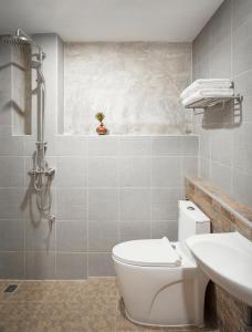 清邁的住宿－清邁斯特普旅館，浴室配有白色卫生间和盥洗盆。