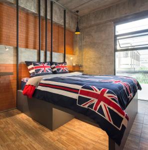 a bedroom with a king sized bed with british flag pillows at The Step Chiang Mai in Chiang Mai