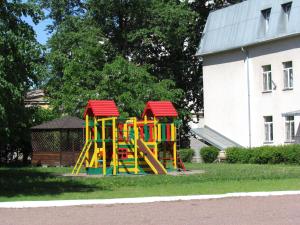 a playground with a slide in the grass next to a building at Logos in Saint Petersburg