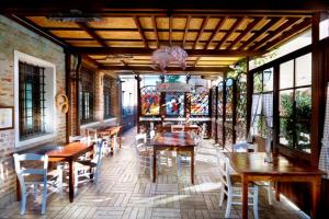 a restaurant with wooden tables and chairs and windows at Al Gallo Nero in Borgoricco