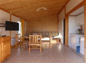 uma cozinha e sala de jantar com mesa e cadeiras em Camping Fraiteux em Plombières-les-Bains