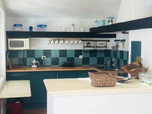 Quinta da Balaia 3 Rooms في ألبوفيرا: مطبخ مع جدران بلاط أخضر ومكتب