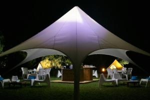 un groupe de chaises sous un parasol blanc la nuit dans l'établissement Village Del Mar - Corse, à Solaro