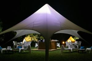 a group of chairs under a white umbrella at night at Village Del Mar in Solaro