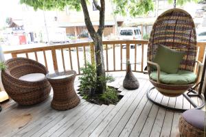 una terrazza in legno con sedie e un albero sopra di Uematsuya a Ueda