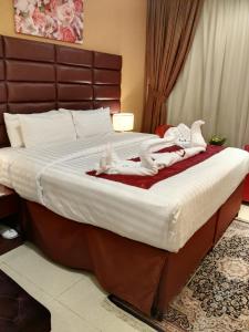 Una cama con toallas blancas en un dormitorio en Al Aseel Hawazen Hotel, en La Meca