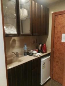 una pequeña cocina con fregadero y lavavajillas en Al Aseel Hawazen Hotel, en La Meca