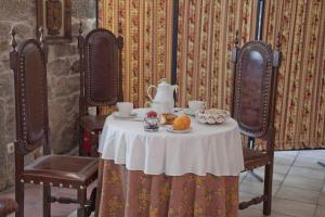 a table with a tea set on top of it at Casa de Turismo Rural Os Petroglifos in Boiro